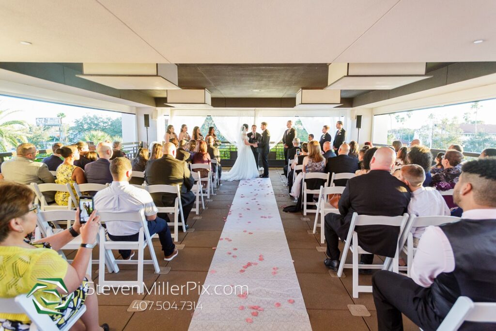 wedding ceremony in room with large windows on all sides so you can feel like you are outside